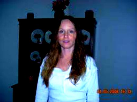 Misty Loman in a white top poses for a picture.